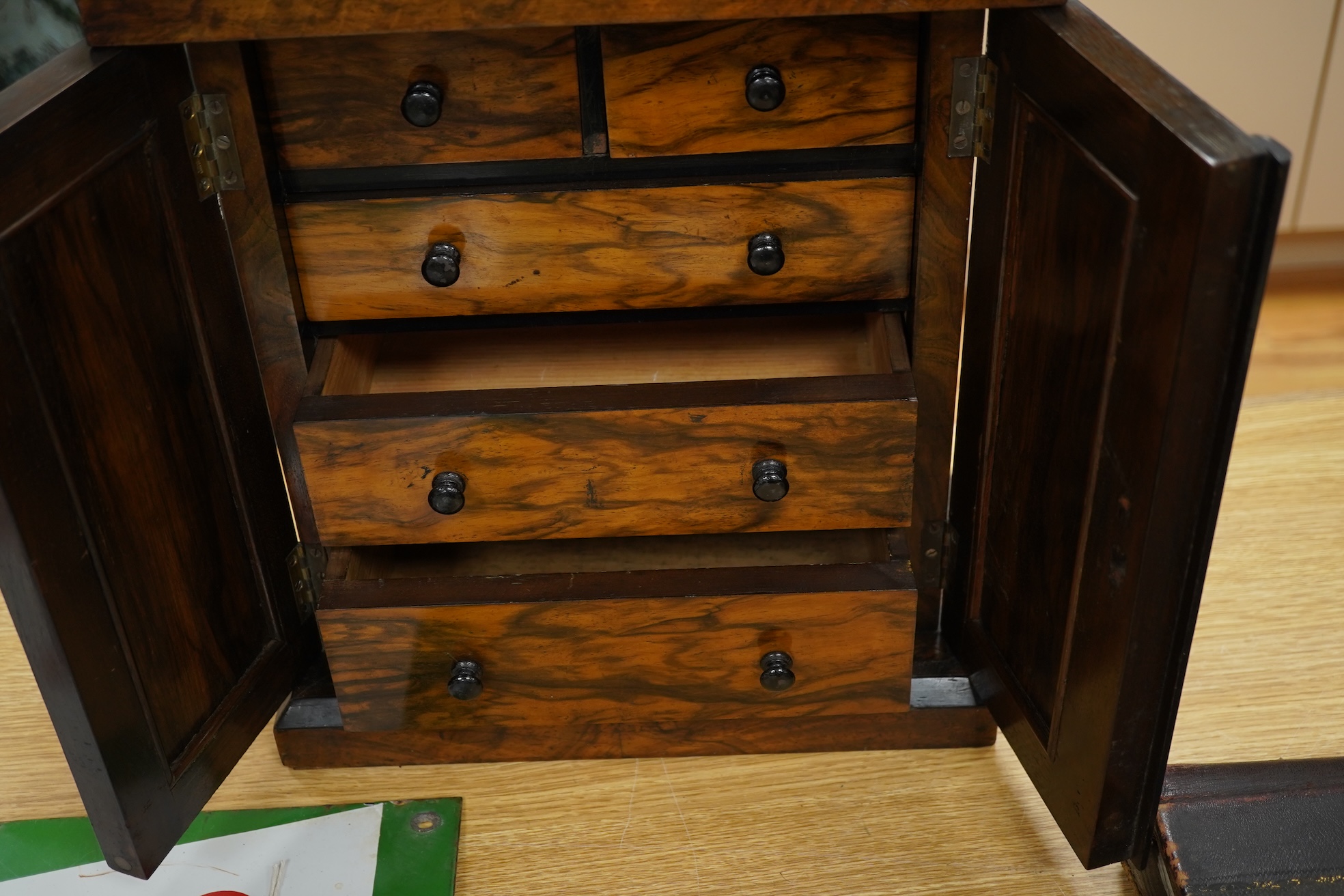 A Victorian walnut miniature two door tabletop cabinet/chest with two short and three long drawers inside. 32cm wide x 37cm high